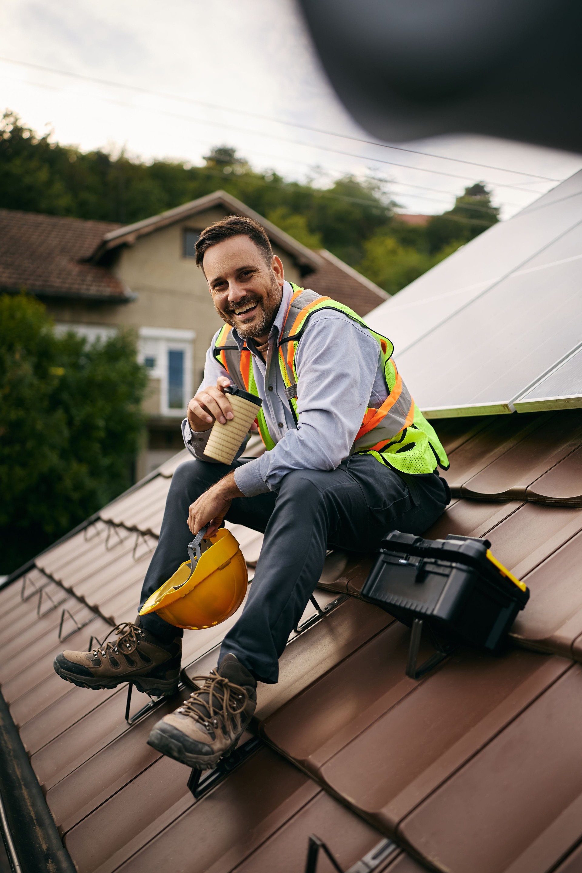 Happy maintenance engineer enjoying on coffee break on the roof.